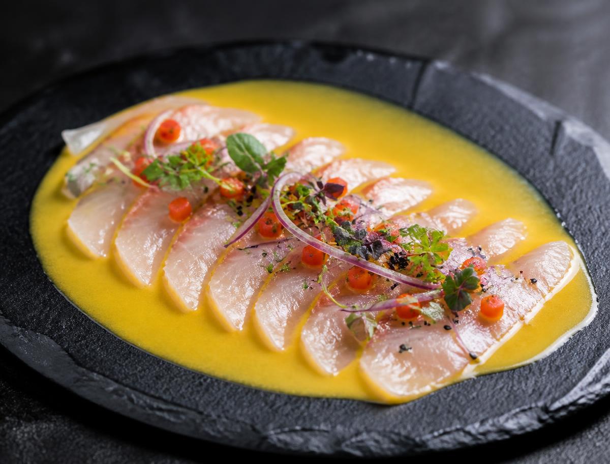 Tiradito de Ají Amarillo — Láminas finas de lenguado con crema de ají amarillo y crocante de maíz.
